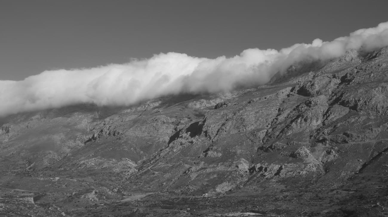 Wolkenband über einem Bergrücken in Schwarz-Weiß